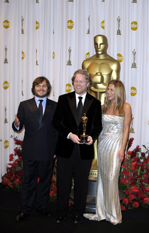 Director Andrew Stanton (C) holds up his trophy for best animated feature of the 81st Academy Awards for 'Wall-E' with Jack Black (L) and Jennifer Aniston at the Kodak Theater in Hollywood, California, the United States, Feb. 22, 2009. [Qi Heng/Xinhua]