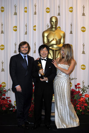  Director Kunio Kato (C) holds up his trophy for best animated short film of the 81st Academy Awards for 'Wall-E' with Jack Black (L) and Jennifer Aniston at the Kodak Theater in Hollywood, California, the United States, Feb. 22, 2009. [Qi Heng/Xinhua]