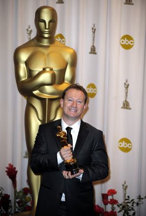 Simon Beaufoy holds up his trophy for best adapted screenplay of the 81st Academy Awards for 'Slumdog Millionaire' at the Kodak Theater in Hollywood, California, the United States, Feb. 22, 2009.[Qi Heng/Xinhua]