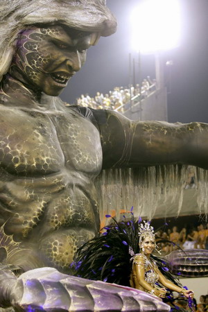 A reveller of Beija-Flor samba school dances atop a float during the first night of the Carnival parade in Rio de Janeiro's Sambadrome, early February 23, 2009. [China Daily/Agencies]