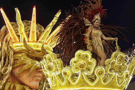 Reveller from Grande Rio samba school dances atop a float during the first night of the Carnival parade in Rio de Janeiro's Sambadrome February 22, 2009. [China Daily/Agencies]