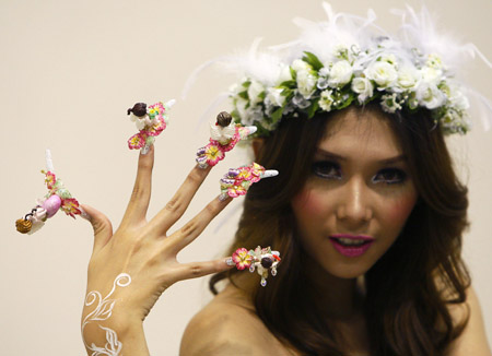 A contestant displays her cupid-themed nails before a nail art competition the BeautyAsia expo in Singapore Feb. 23, 2009. [Xinhua/Reuters]