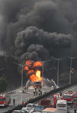 Firemen attempt to extinguish fire at the wreckage of an oil truck that self-ignited on the Dongguan-Shenzhen Expressway in south China's Guangdong Province, Feb. 23, 2009. The fire of the truck, which also caused a forest fire nearby, was put out in two hours. The forest fire was also under control.[Xinhua] 