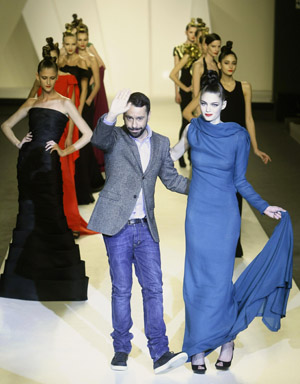 Designer Juanjo Oliva waves next to models wearing his creations during the Pasarela Cibeles Autumn/Winter 09-10 fashion week in Madrid Feb. 23, 2009. [Xinhua/Reuters]