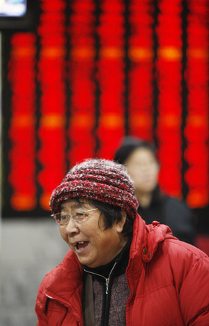 A stock holder reacts in front of a board displaying the Shanghai Composite Index in Shanghai, China, on Feb. 23, 2009. [Xinhua]