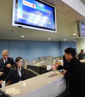 A Chinese passenger (R) checks in at the airport in Algiers, Algeria, on Feb. 22, 2009. The Air Algerie's first non-stop flight to <a href=http://www.chinakindnesstour.com/cityguide/beijing/ target=_blank class=infotextkey>Beijing</a> started on Sunday, while the price of the ticket is about 958 US dollars.