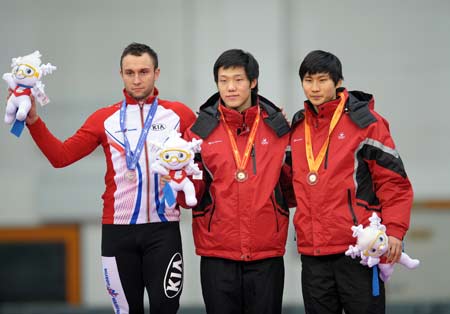 Mo Tae Bum (C) of South Korea takes a photo with his compatriot Lee Kang Seok (R) and Polish Konrad Niedzwiedzki during the awarding ceremony for the men's 1000m final of speed skating in the 24th Winter Universiade at Heilongjiang Speed Skating Gym in Harbin, capital of northeast China's Heilongjiang Province, Feb. 24, 2009. 