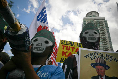 Protesters wear masks as they try to march towards the U.S. Embassy during a rally in Manila, capital of Philippines, Feb. 24, 2009. 