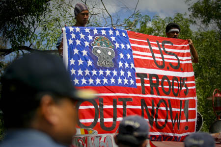 Protesters hold a huge mock U.S. national flag as they try to march towards the U.S. Embassy during a rally in Manila, capital of Philippines, Feb. 24, 2009. 