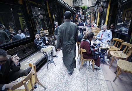 Tourists drink coffee and smoke water pipe in the narrow alleyways of Khan Al-Khalili bazaar in Cairo, capital of Egypt, Feb. 23, 2009. Shops and restaurants around the Hussein mosque square and in the Khan Al-Khalili bazaar reopened for business on Monday, although two bombs blew up Sunday evening in this populous district, which had killed a French tourist and injured 24. [Zhang Ning/Xinhua]