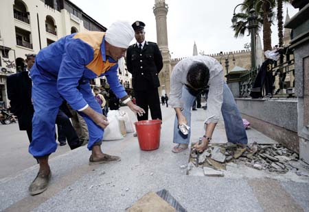 Two workers clear the ruined floor at the blast scene located between the al-Hussein mosque and the Khan Al-Khalili bazaar in Cairo, capital of Egypt, Feb. 23, 2009. Shops and restaurants around the Hussein mosque square and in the Khan al-Khalili bazaar reopened for business on Monday, although two bombs blew up Sunday evening in this populous district, which had killed a French tourist and injured 24. [Zhang Ning/Xinhua]