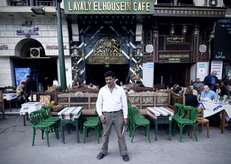 A waiter of Layaly El-Housin Cafe waits for customers near Khan Al-Khalili bazaar in Cairo, capital of Egypt, Feb. 23, 2009. Shops and restaurants around the Hussein mosque square and in the Khan Al-Khalili bazaar reopened for business on Monday, although two bombs blew up Sunday evening in this populous district, which had killed a French tourist and injured 24. [Zhang Ning/Xinhua]