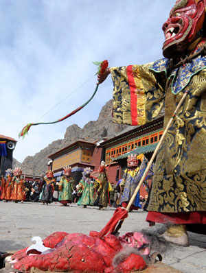  A monk 'kills' devil during the Lamaist devil dance ceremony at Tsurpu Monastery, about 70 kilometers of Lhasa, capital of southwest China's Tibet Autonomous Region, Feb. 23, 2009. [Chogo/Xinhua]