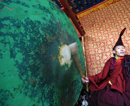 A monk strikes a drum during the Lamaist devil dance ceremony at Tsurpu Monastery, about 70 kilometers of Lhasa, capital of southwest China's Tibet Autonomous Region, Feb. 23, 2009. [Chogo/Xinhua]