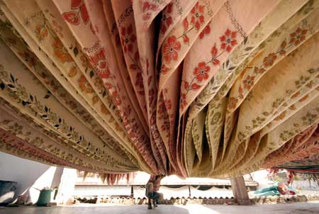 A worker dries saris at a cotton sari factory in the southern Indian city of Hyderabad February 24, 2009. Sari is a traditional dress for Indian woman.[Xinhua/Reuters]