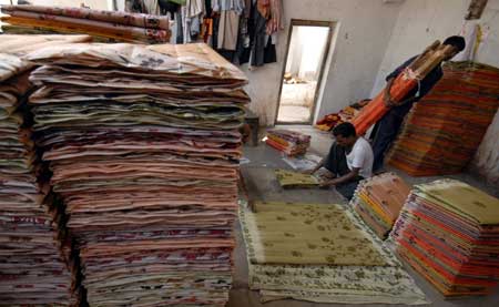  A worker folds saris at a cotton sari factory in the southern Indian city of Hyderabad February 24, 2009.[Xinhua/Reuters]