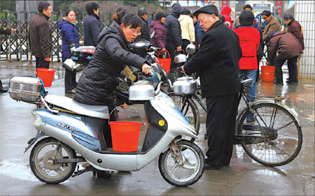 Yancheng residents arrive at the Jiangsu Jianghui Engine Co Ltd factory to get clean water from its deep well during the city's water pollution crisis, February 22, 2009. [China Daily] 