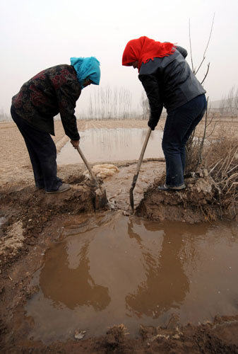 Farmers diverted water from a river to irrigate their crops in Lanzhou, Gansu Province, on February 18, 2009.