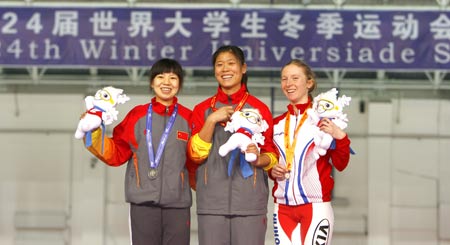 Gold medalist China's Dong Feifei (C) and her teammate silver medalist Fu Chunyan (L) and bronze medalist Poland's Luiza Zlotkowska pose for group pictures during the awarding ceremony for women's 5000m of speed skating in the 24th World Winter Universiade at Heilongjiang Speed Skating Gym in Harbin, capital of northeast China's Heilongjiang Province, Feb. 24, 2009. (Xinhua Photo) 