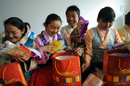 Tibetan students unpack the gifts from local people before the Tibetan New Year which falls on Feb. 25 this year at Jinan Tibetan School in Jinan, capital of east China's Shandong Province, Feb. 24, 2009. 