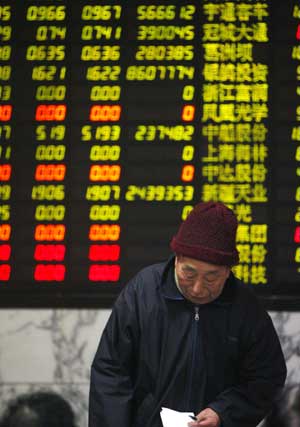  A stock holder stands in front of the electronic board of share prices at a securities exchange in Shanghai, China, on Feb. 24, 2009.[Xinhua]