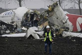 A Forensic expert is seen near the wreckage of a Turkish Airlines plane at Amsterdam's Schiphol Airport Wednesday, Feb. 25, 2009. [Peter Dejong/CCTV/AP Photo] 