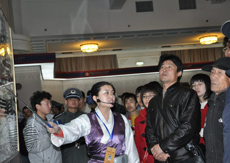 A guide introduces photos at an exhibition marking the 50th anniversary of the Democratic Reform in Tibet Autonomous Region in Beijing, Feb. 25, 2009. (Xinhuanet Photo) 