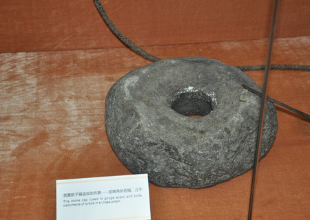 A stone cap that was used to gouge eyes of serfs in a Lhasa prison in old Tibet is on display at an exhibition marking the 50th anniversary of the Democratic Reform in Tibet Autonomous Region in Beijing, Feb. 25, 2009. (Xinhuanet Photo)