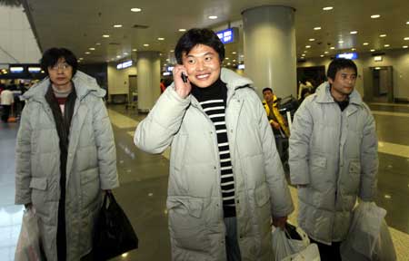 Li Guangchao (C), a crew member of the sank cargo ship 'New Star', calls his family upon his arrival at the airport in Beijing, capital of China, Feb. 25, 2009. The cargo ship sank off Russia's far-east port of Vladivostok on Sunday after coming under fire from Russian coast guard vessels. Three Chinese crew members were rescued.