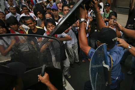 Protestors confront with policemen during a demonstration outside the United States Embassy in Manila, capital of the Philippines, Feb. 25 2009. Militant groups on Wednesday organized the demonstration, calling for the abolition of the Philippines-U.S. Visiting Forces Agreement (VFA), which allows the presence of U.S. troops in the Philippines for military exercises and humanitarian missions. (Xinhua/Luis Liwanag)