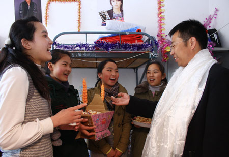 A teacher (R) congratulates Tibetan students in Tibetan style on the first day of Tibetan new year at Liaoyang First High School in north China's Liaoning Province on Feb. 25, 2009. Tibetans across China are celebrating the 50th Tibetan New Year after the Democratic Reform with their old traditions. (Xinhua/Cao Jingyi)