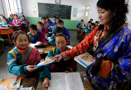 Students receive free textbooks on the first day of new semester in the School for Nationalities in Tianzhu Tibet Autonomous County, northwest China's Gansu Province, Feb. 25, 2009. Tibetans across China are celebrating the 50th Tibetan New Year after the Democratic Reform with their old traditions. (Xinhua/Han Chuanhao)