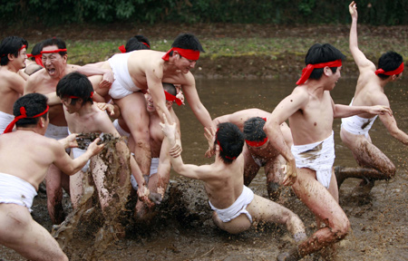 Residents attend a traditional 'Mud Festival' ceremony in the rice field on the outskirts of Yotsukaido City, Chiba prefecure, suburban Tokyo, Japan, on Feb. 25, 2009. 