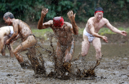 Residents attend a traditional 'Mud Festival' ceremony in the rice field on the outskirts of Yotsukaido City, Chiba prefecure, suburban Tokyo, Japan, on Feb. 25, 2009.