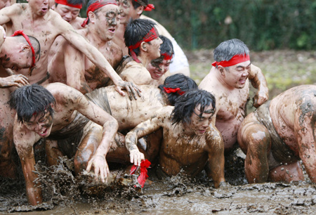 Residents attend a traditional 'Mud Festival' ceremony in the rice field on the outskirts of Yotsukaido City, Chiba prefecure, suburban Tokyo, Japan, on Feb. 25, 2009. 