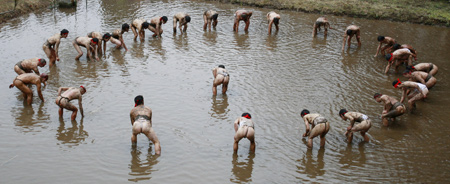 Residents attend a traditional 'Mud Festival' ceremony in the rice field on the outskirts of Yotsukaido City, Chiba prefecure, suburban Tokyo, Japan, on Feb. 25, 2009. 