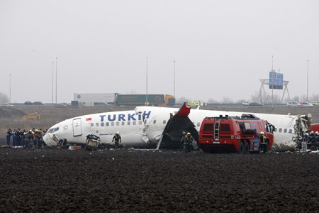 Emergency workers gather round the cockpit of a Turkish Airlines passenger plane with 135 people aboard which crashed while attempting to land at Amsterdam's Schiphol airport February 25, 2009.