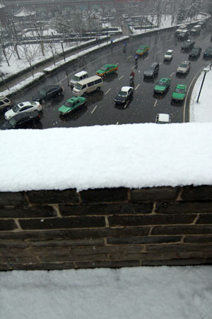 Cars run in snow in Xi'an, capital of northwest China's Shaanxi Province, Feb. 26, 2009. Majority of Shaanxi Province witnessed the first snow of this spring on Thursday. [Ding Haitao/Xinhua]