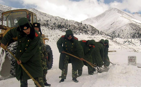 Soldiers shovel snow from a road blocked by an avalanche on the Sichuan-Tibet Highway between Baxoi and Bomi counties in southwest China's Tibet autonomous region, February 26, 2009. [cnr.cn] 