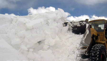 A soldier drives a front-end loader to shovel a road blocked by an avalanche on the Sichuan-Tibet Highway between Baxoi and Bomi counties in southwest China's Tibet autonomous region, February 26, 2009. [cnr.cn] 