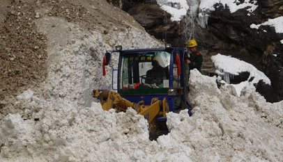 A soldier drives a front-end loader to dig the snow off a road blocked by an avalanche on the Sichuan-Tibet Highway between Baxoi and Bomi counties in southwest China's Tibet autonomous region, February 26, 2009. [cnr.cn] 