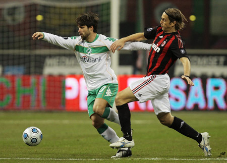 AC Milan's Massimo Ambrosini (R) fights for the ball with Werder Bremen's Diego during their UEFA Cup soccer match at the San siro stadium in Milan February 26, 2009.[Xinhua/Reuters Photo]