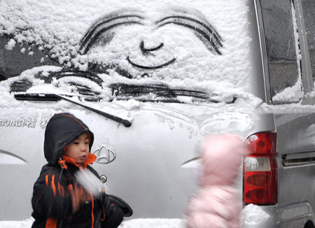Kids play in snow in Xi'an, capital of northwest China's Shaanxi Province, Feb. 26, 2009. Majority of Shaanxi Province witnessed the first snow of this spring on Thursday. (Xinhua/Tao Ming)