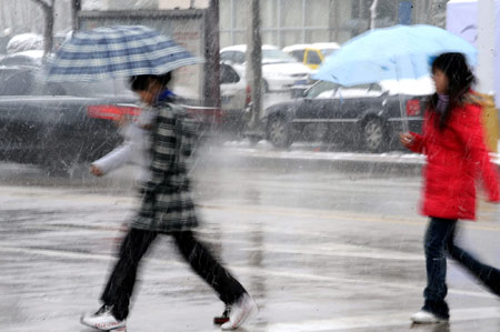 Two women walk in snow in Xi'an, capital of northwest China's Shaanxi Province, Feb. 26, 2009. Majority of Shaanxi Province witnessed the first snow of this spring on Thursday. (Xinhua/Tao Ming) 