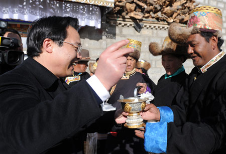 Sun Deyue (1st L), a cadre from Beijing, who is the Doilungdeqen County's party secretary, celebrates the Tibetan New Year with his Tibetan friends in Lhasa, capital of southwest China's Tibet Autonomous Region, Feb. 26, 2009, the second day of the 'earth ox' year on the Tibetan calendar.