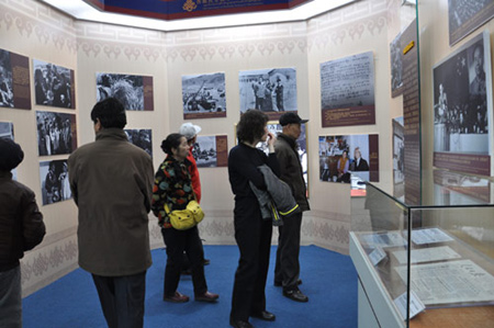 Photo taken on Feb. 26, 2009 shows visitors watch pictures recording the crack-down on the armed rebellion staged by a small number of reactionary monks, serfowners and officials in 1956 at the 50th Anniversary of Exhibition of Democratic Reforms in Tibet. 