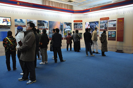 Photo taken on Feb. 26, 2009 shows visitors watch pictures and videos at the third hall of the 50th Anniversary of Democratic Reforms in Tibet Exhibition, which runs from Feb. 24 to Apr. 10 at the Exhibition Center of the Cultural Palace of Nationalities, Beijing. 