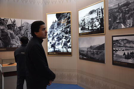 Photo taken on Feb. 26, 2009 shows a Uigur young man watches pictures about the peaceful liberation of Tibet at the 50th Anniversary of Democratic Reforms in Tibet Exhibition, which runs from Feb. 24 to Apr. 10 in the Exhibition Center of the Cultural Palace of Nationalities, Beijing. 