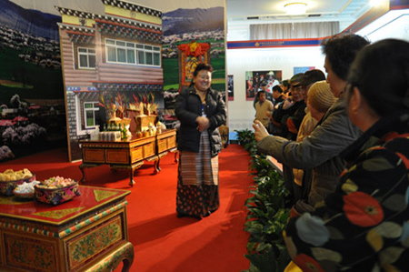 Photo taken on Feb. 26 shows visitors ask a guide questions about custom and habits appear during the Tibetan New Year in the third hall of the 50th Anniversary of Democratic Reforms in Tibet Exhibition, which runs from Feb. 24 to Apr.10 at the Exhibition Center of the Cultural Palace of Nationalities, Beijing. 