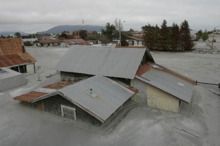 Houses are buried in ashes after the eruption of Chaiten volcano near Chaiten town, located some 1,200 km south of Santiago, Chile, Feb. 26, 2009. The Chaiten volcano, which started erupting on Feb. 19, has buried the neighboring towns under a blanket of ashes.